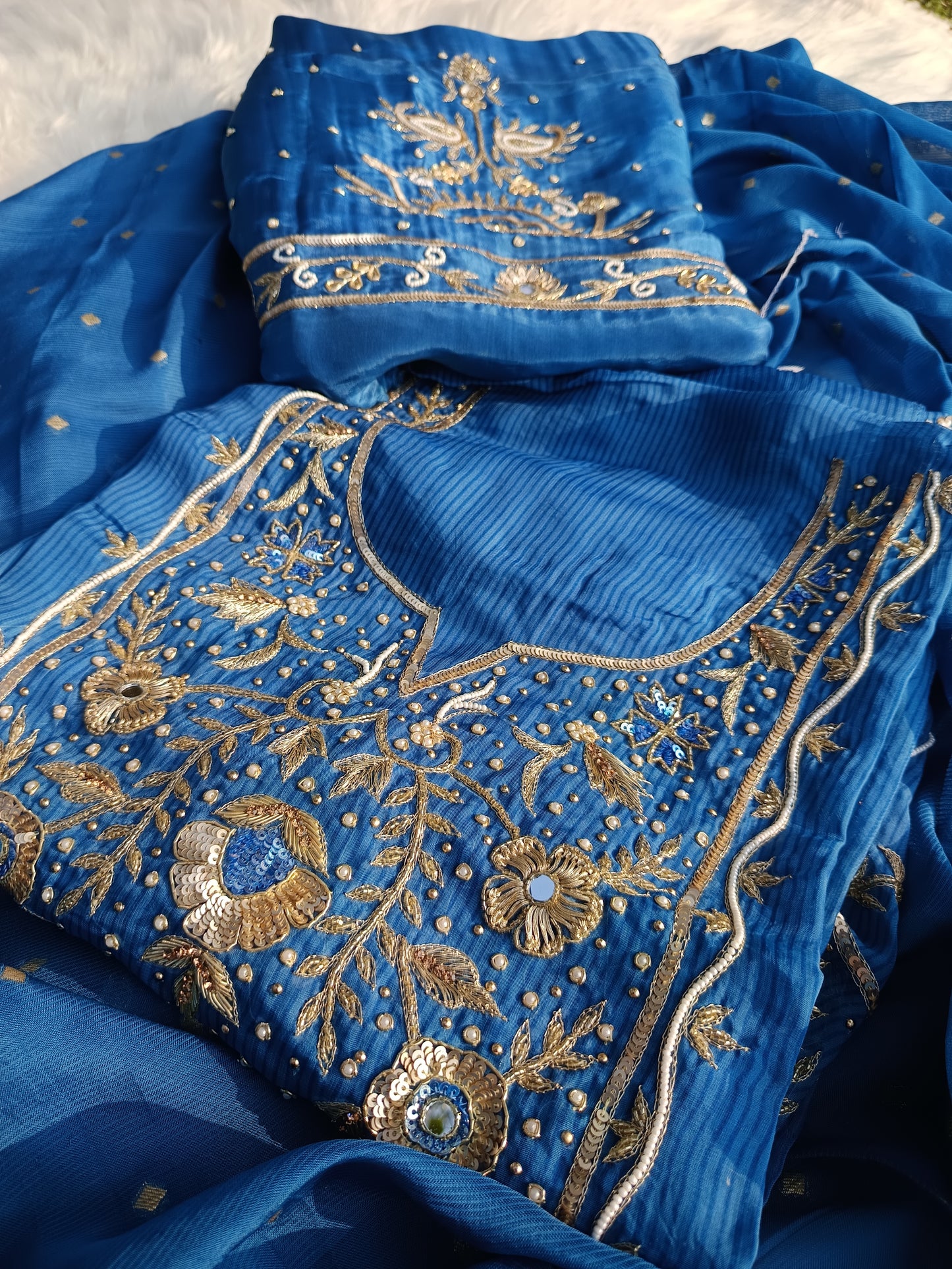 Closeup of hand embroidery and delicate detailing on organza fabric.