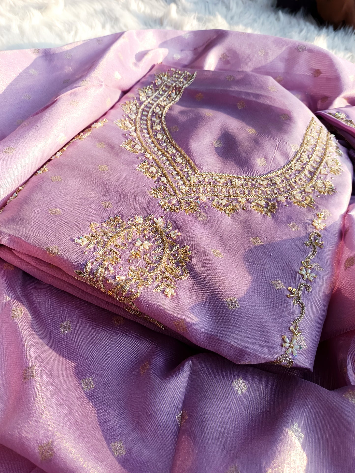 Close-up of intricate hand embroidery on pure tissue silk suit for women.