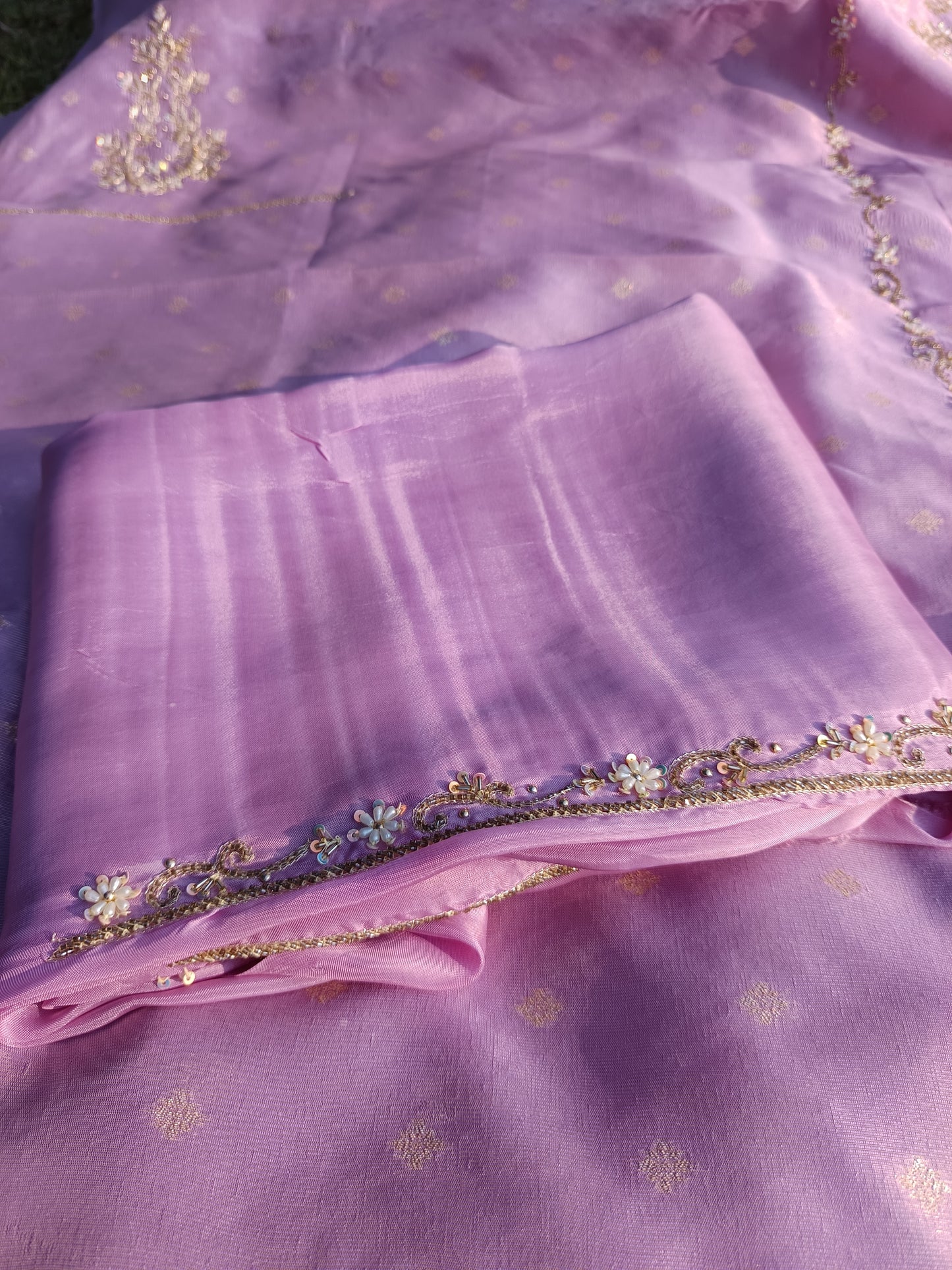Zoomed-in shot of delicate handcrafted embroidery work on tissue silk fabric.