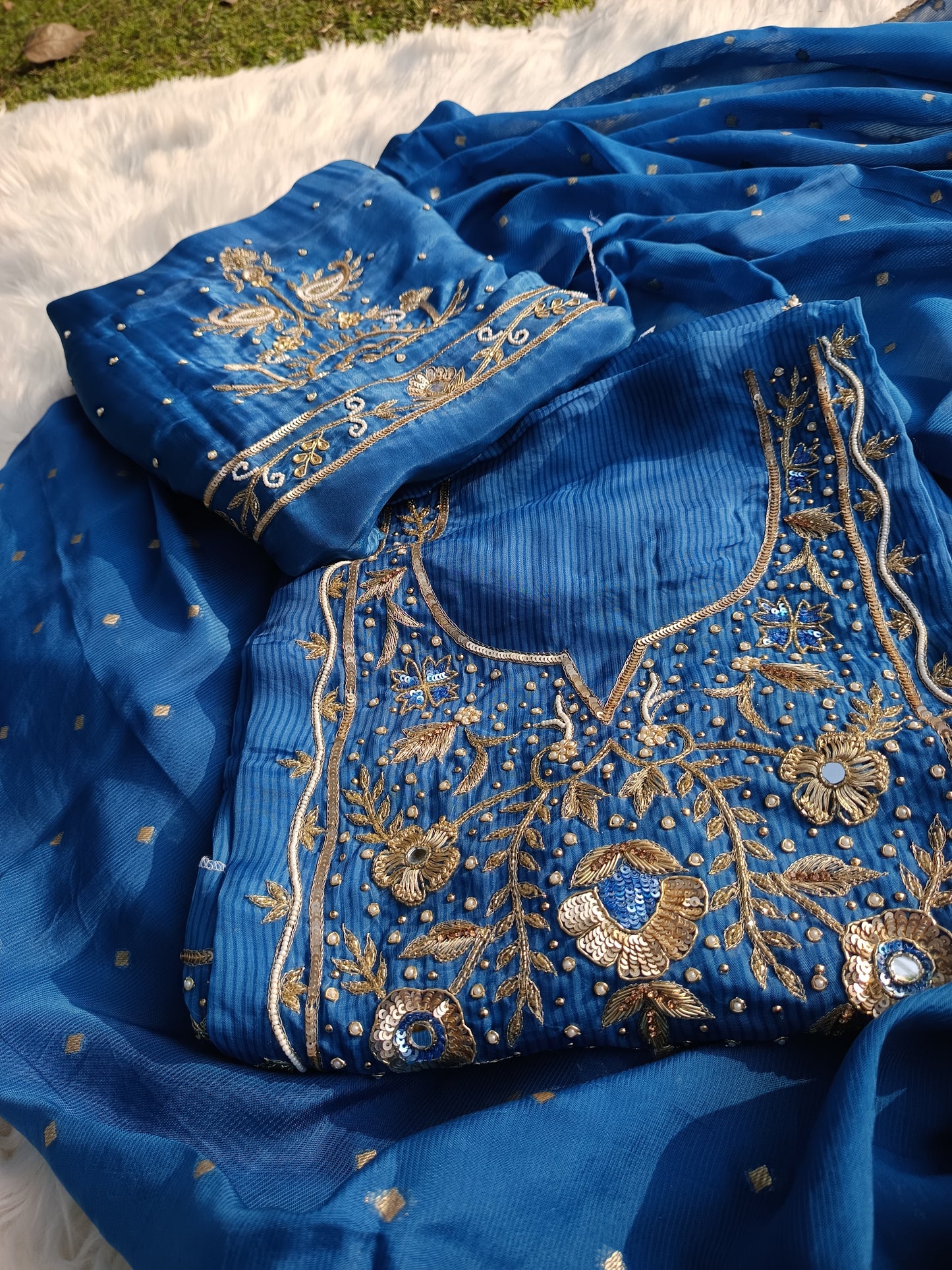 Detailed embroidery work on luxurious organza fabric in elegant tones.