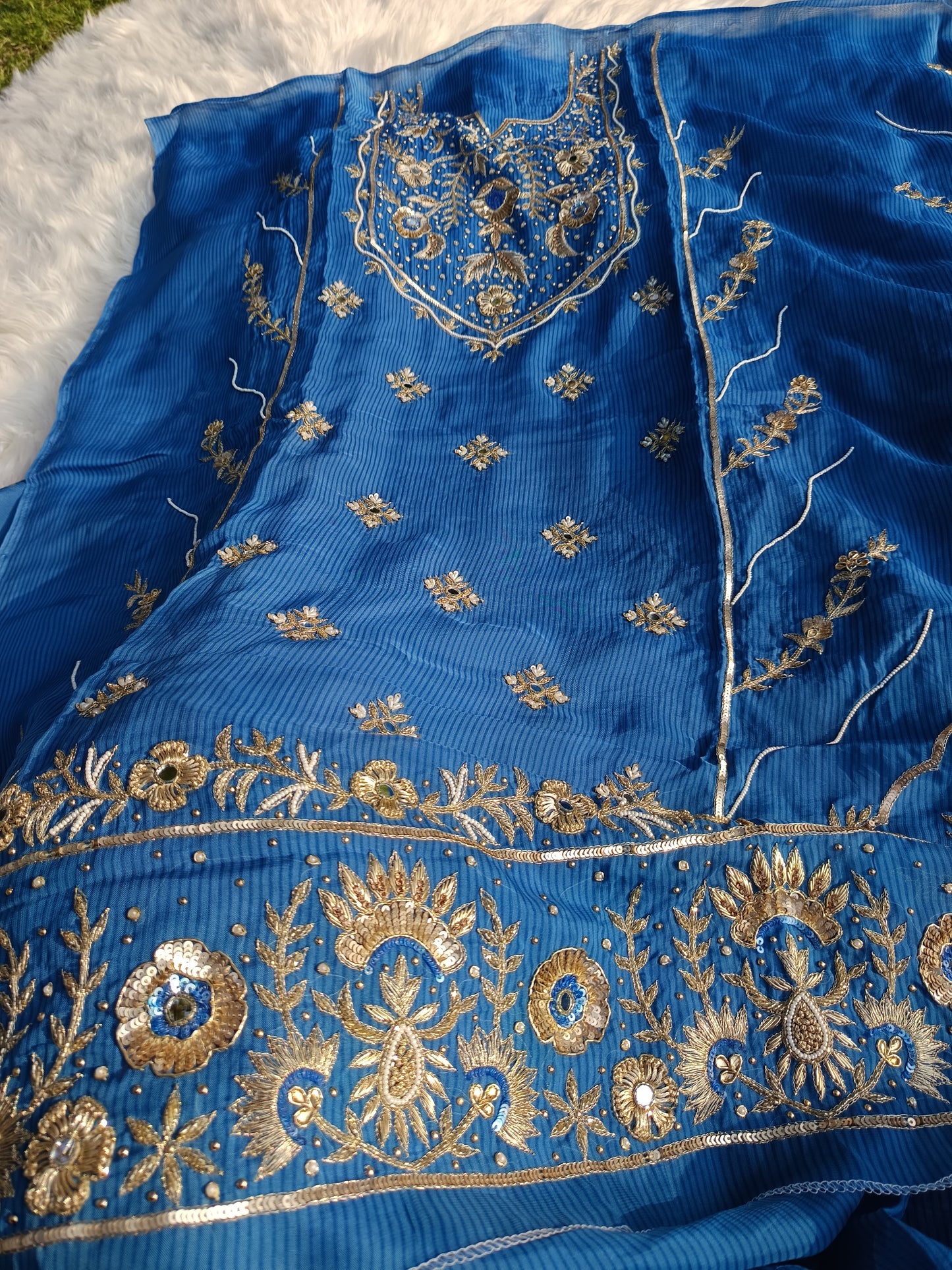 Closeup of embellished patterns and handwork on the soft organza material.