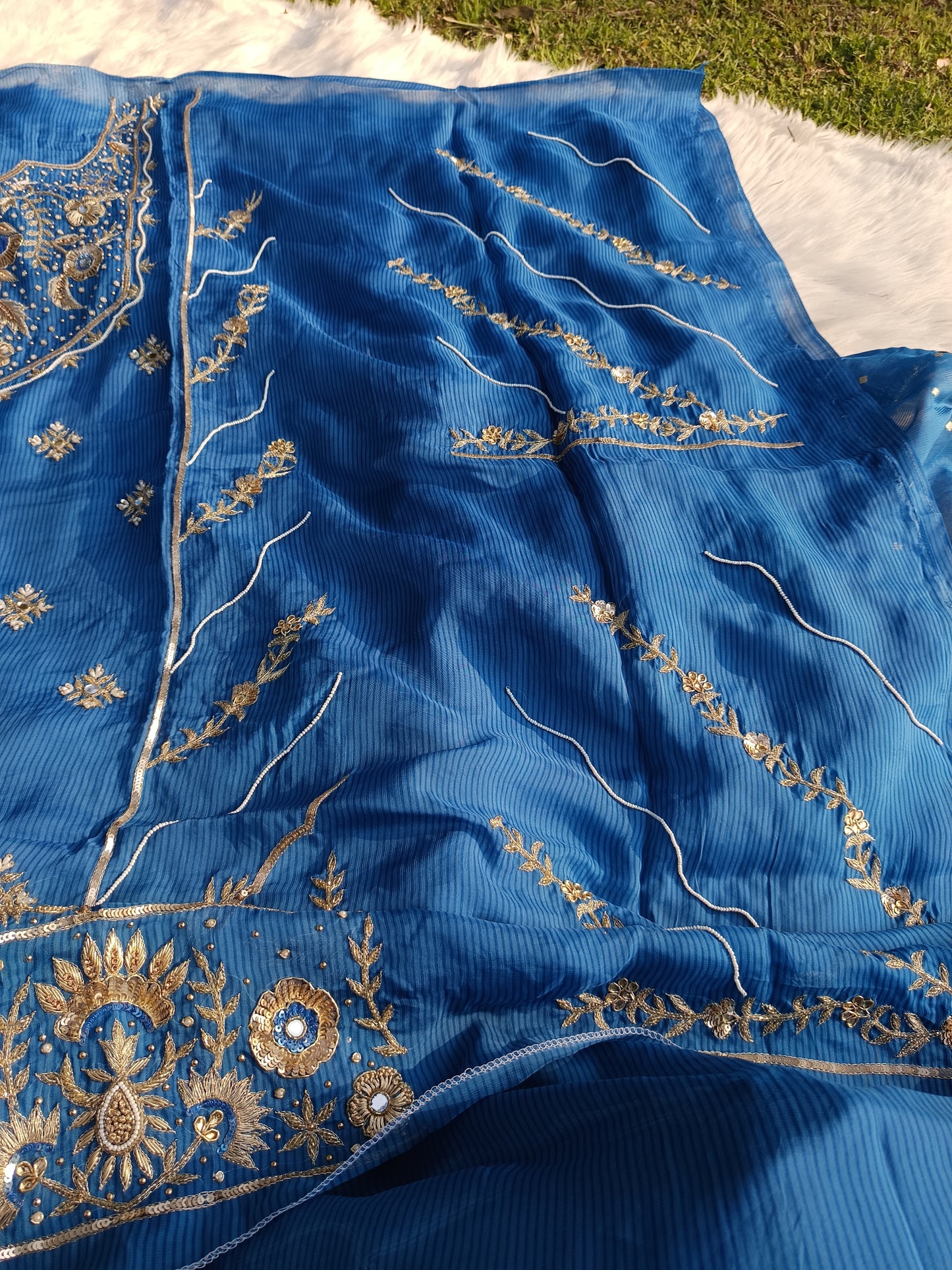 Designer organza suit with intricate handwork shown in a curated outfit layout.