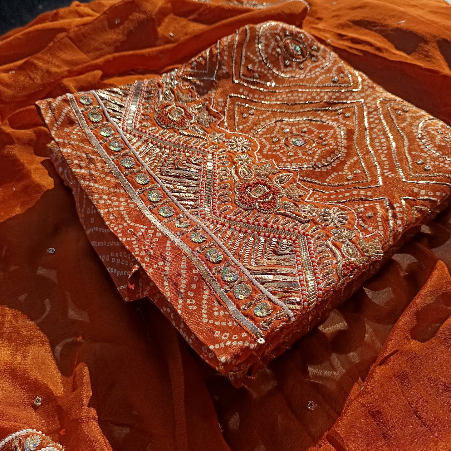 Beautiful silk suit adorned with intricate Bandhani tie-dye designs, perfect for festive occasions.