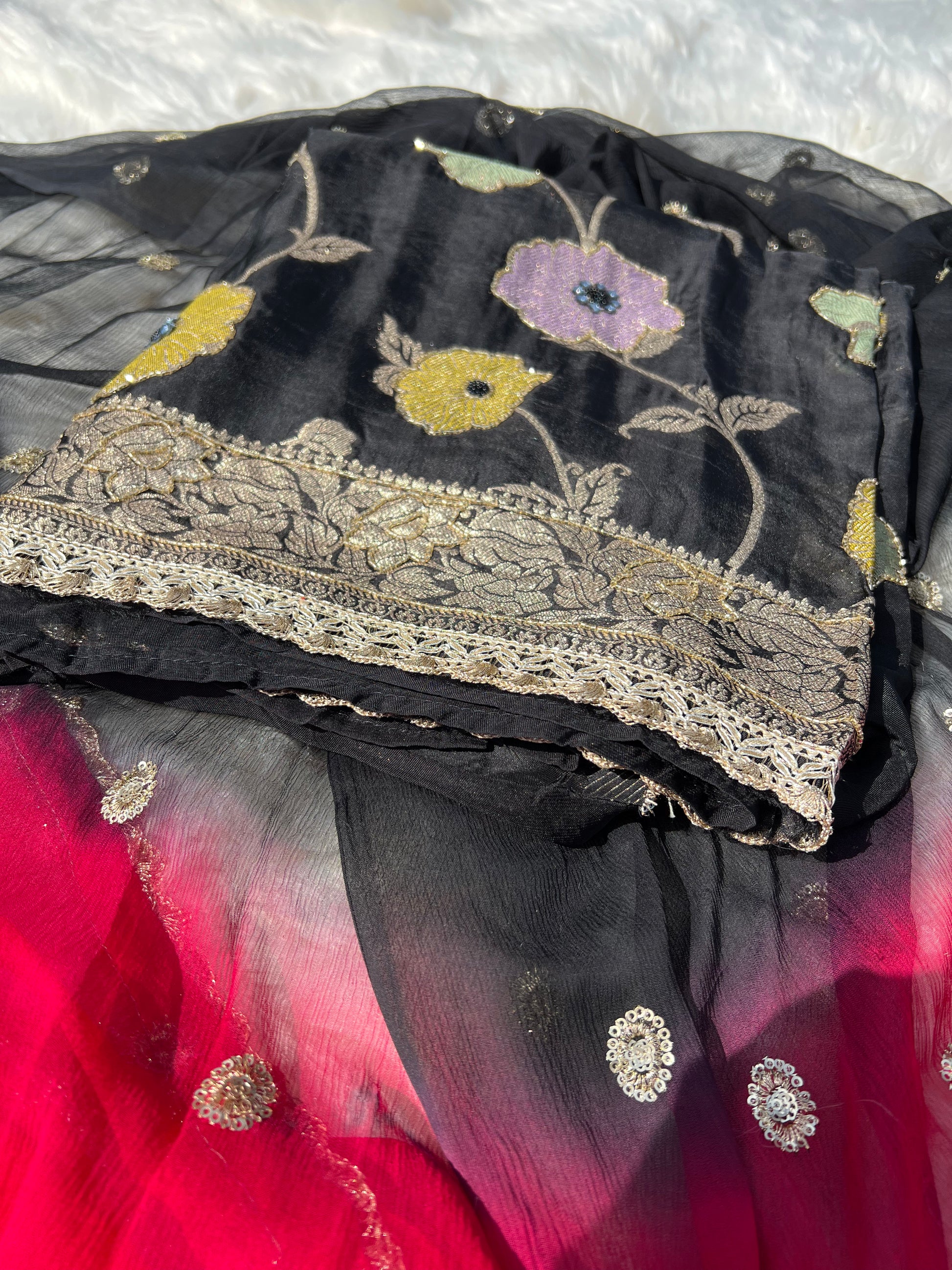 Richly draped Banarasi georgette suit in black with traditional golden patterns.