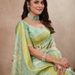 Lady in light green printed saree posing indoors