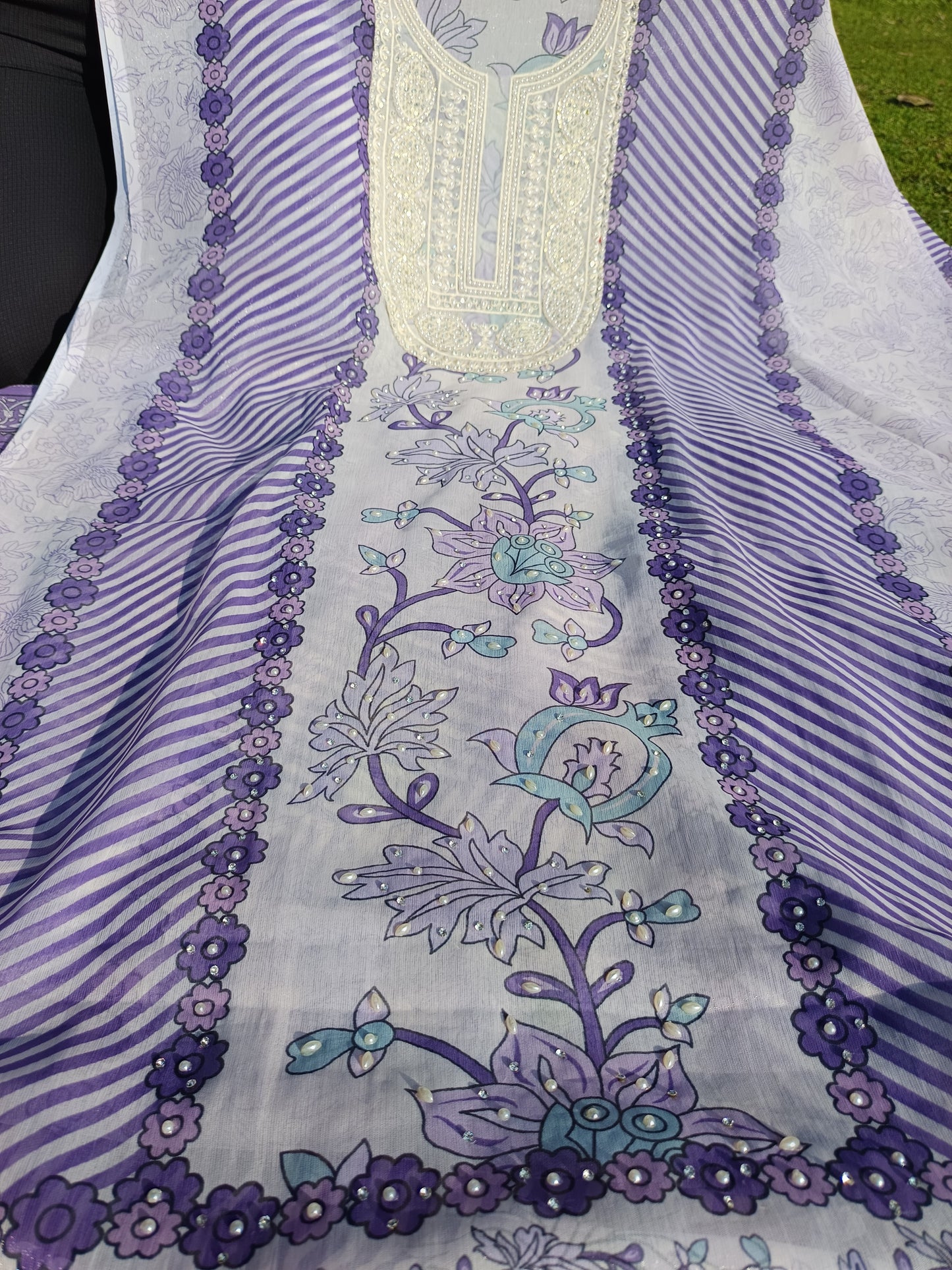 Flatlay of pearl work suit showcasing kurta, pants, and dupatta set