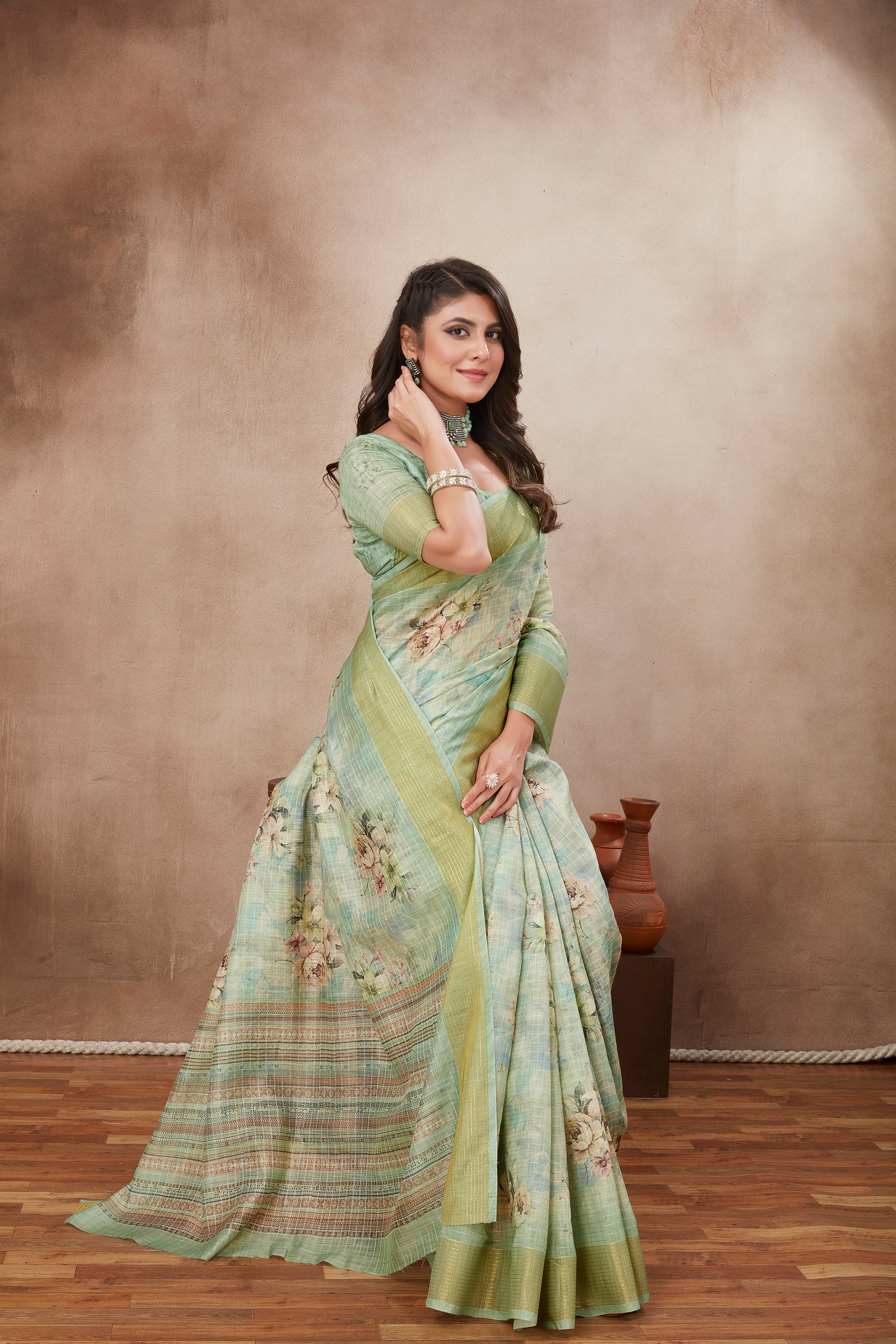 Model in mint green saree with floral patterns and matching blouse