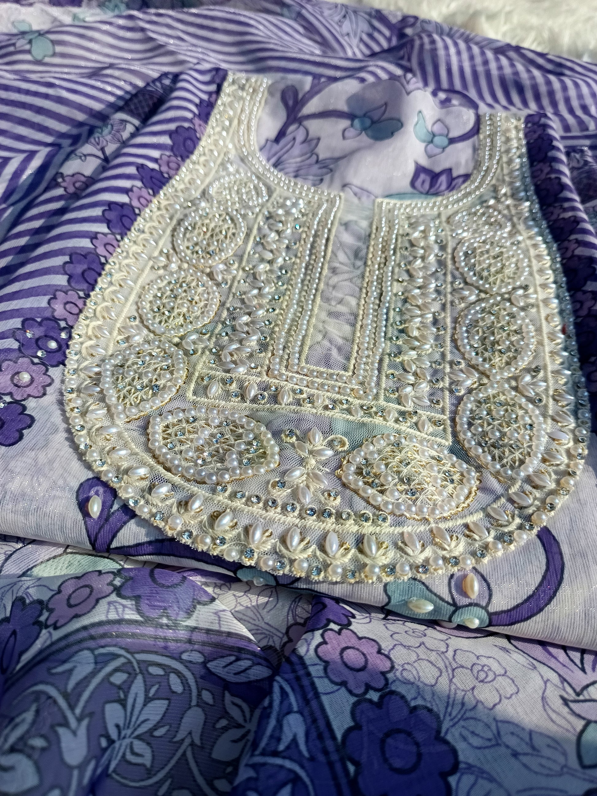 Detailed shot of pearl embroidery around the neckline on soft georgette