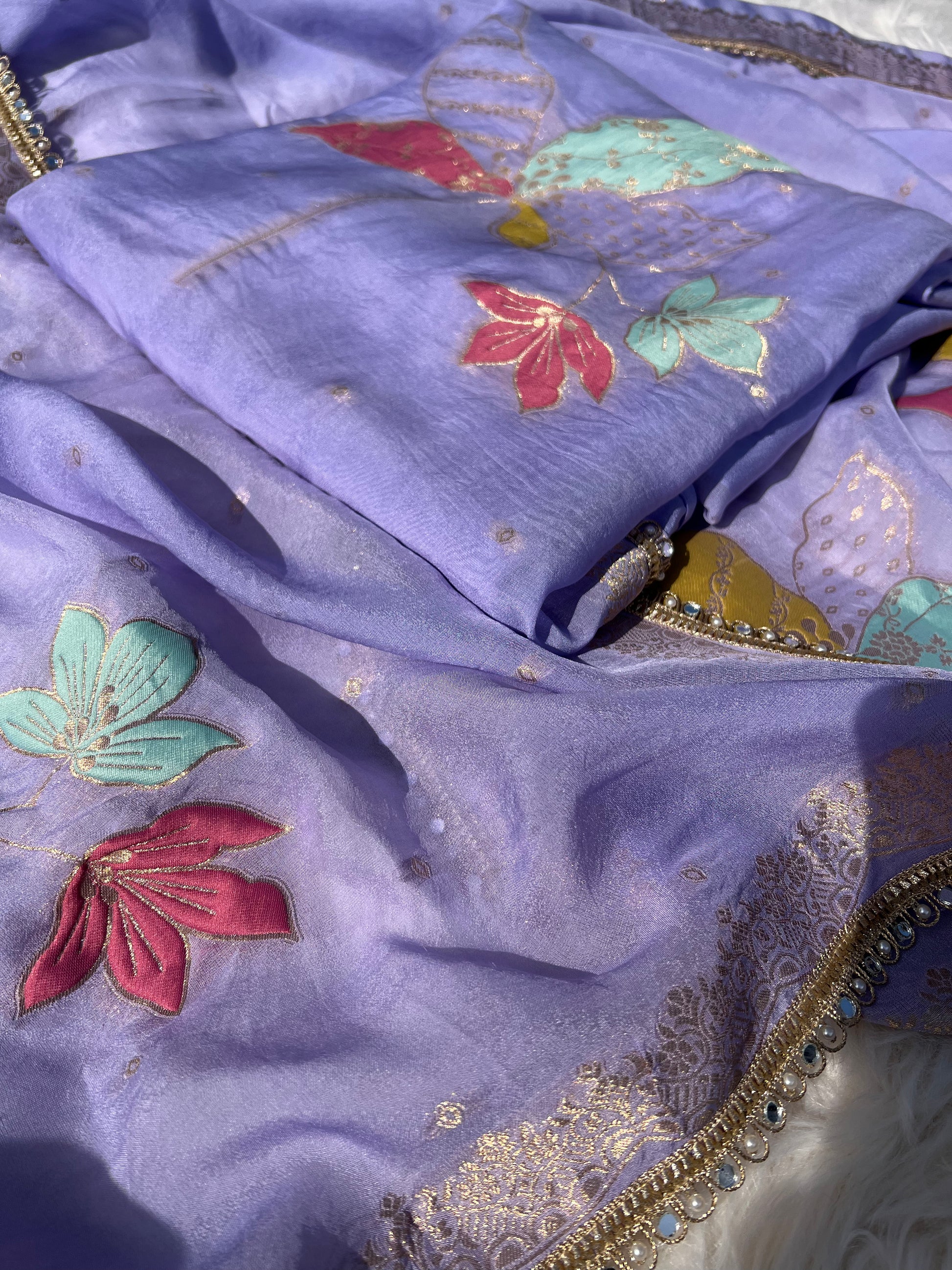 Close-up of embroidery work on the purple silk organza suit